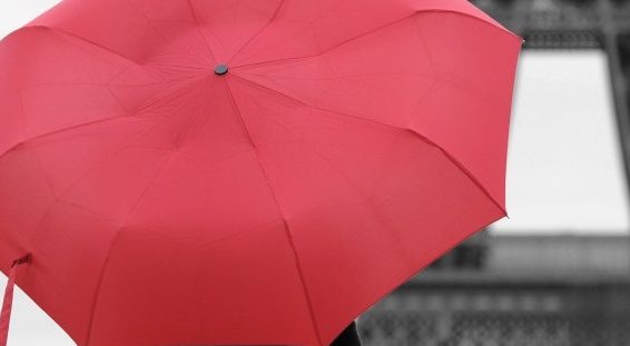 A lady with red umbrella walking in front of Eiffel Tower at a rainy day, Paris
